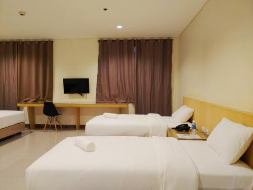 a hotel room with two beds and a couch at Kaizen Suites in Manila