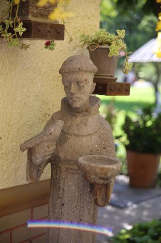 a statue of a person holding a bird bath at La Casita de Fraida in Guadalajara