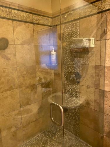 baño con ducha y puerta de cristal en Tuscany Dorado Resort en Cameron Park