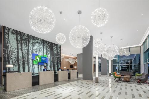 a lobby with chandeliers and furniture in a building at Holiday Inn Express Kota Kinabalu City Centre, an IHG Hotel in Kota Kinabalu