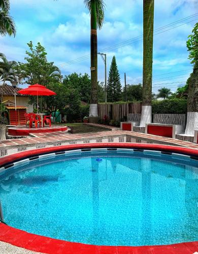 a large blue swimming pool with a red stripe around it at Finca El Bazar in Montenegro