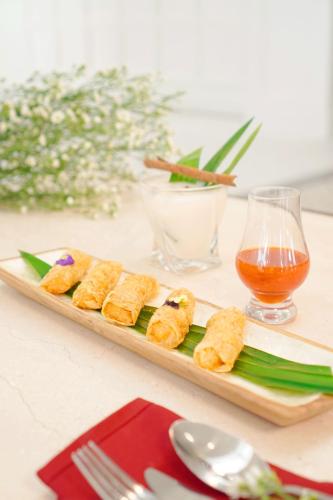 a tray of food on a table with a drink at MAHALAYA The Legacy Hotel in Solo