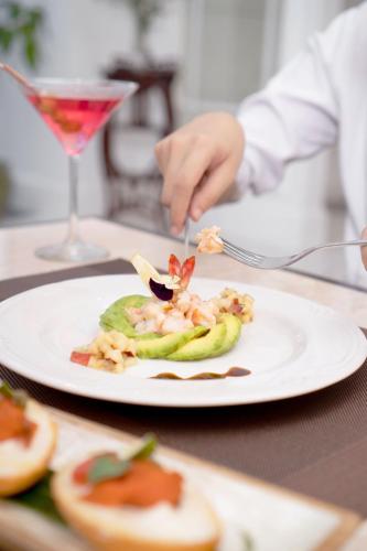 a person eating food on a plate on a table at MAHALAYA The Legacy Hotel in Solo