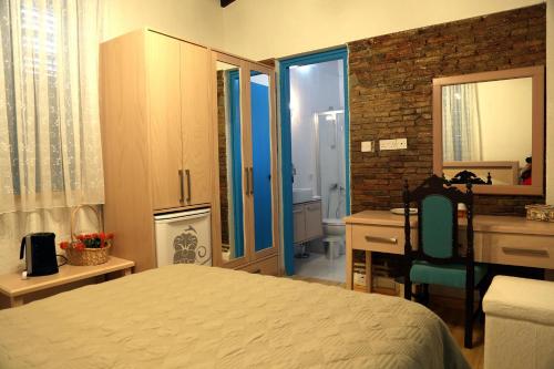 a bedroom with a bed and a desk and a bathroom at Cypriot Swallow Boutique Hotel in North Nicosia