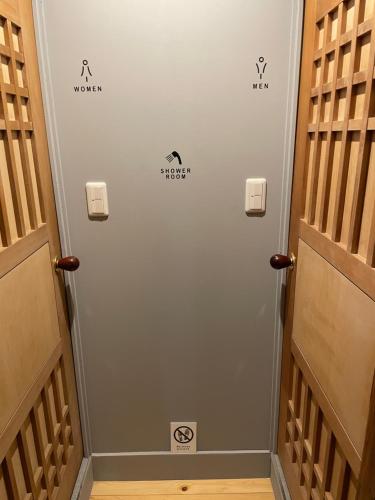 a hallway with a door with signs on it at Beppu hostel&cafe ourschestra in Beppu