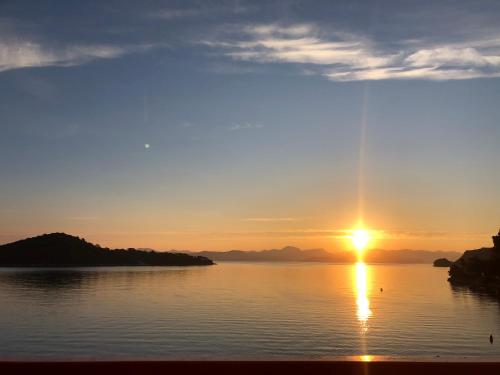 um pôr do sol sobre um corpo de água com o pôr do sol em Villa Anita em Sobra