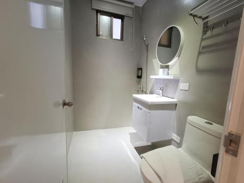 La salle de bains est pourvue de toilettes, d'un lavabo et d'un miroir. dans l'établissement No 9 Hotel-九號文旅, à Tainan
