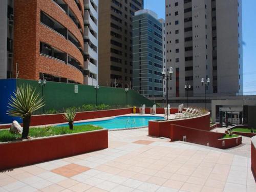 a swimming pool in a city with tall buildings at Porto de Iracema Beach Apartamentos in Fortaleza