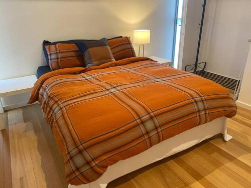 a large orange bed in a small room with at Bayview Retreat - Esplanade home w wifi in Wallaroo