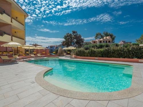 una piscina in un hotel con sedie e ombrelloni di Belvilla by OYO Mirti Bianchi Bilo a Santa Teresa di Gallura