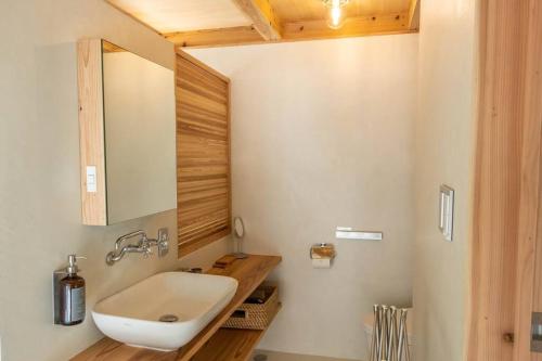 een badkamer met een wastafel en een spiegel bij 久米島 SHINMINKA Villa in Kumejima