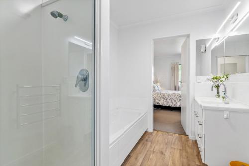 baño blanco con ducha y lavamanos en Views over Blenheim - Blenheim Holiday Home en Blenheim