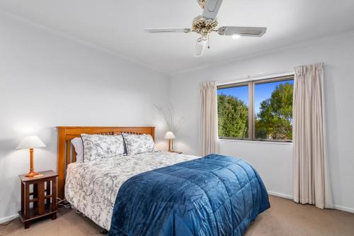 a white bedroom with a bed and a window at Views over Blenheim - Blenheim Holiday Home in Blenheim