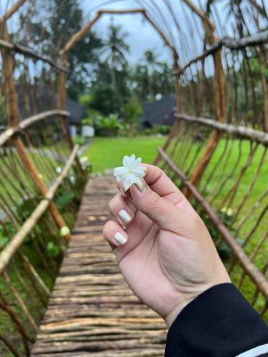 a person holding a flower in their hand on a bridge at Bintana sa Paraiso Binunsaran in Mambajao