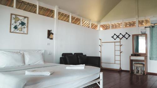 a bedroom with a white bed and a chair at Holiday Resort - SHA Plus in Ko Yao Noi