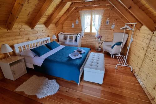 1 dormitorio con 1 cama y 1 silla en una cabaña de madera en 54 Green Road Varaždin en Kućan Marof