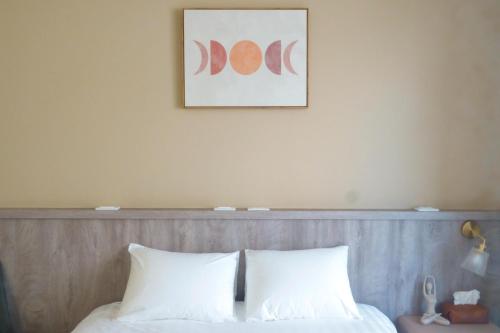 台東市的住宿－宿嘻民宿，一张带两个白色枕头的床和一张墙上的照片