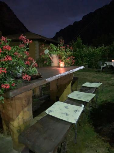 a table and benches in a garden at night at Bed & Breakfast Casa Marinella in Lenna