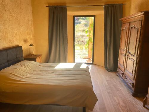 Un dormitorio con una cama y una ventana grande. en Paillehouse Vosges, en Denipaire