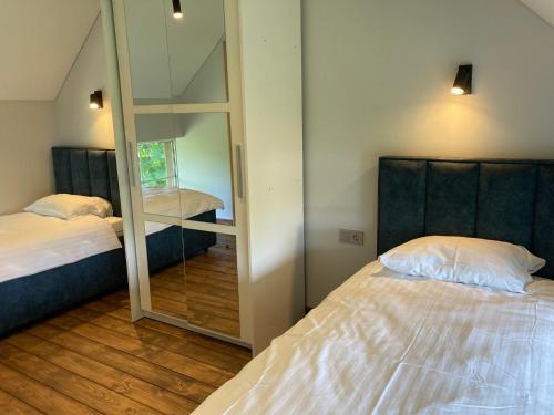 a bedroom with two beds and a mirror at Pape Rogas in Pape