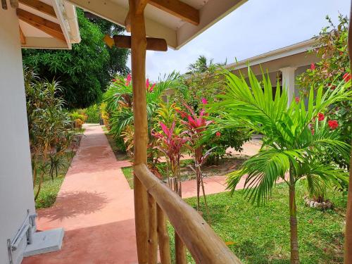 a porch of a house with palm trees and a walkway at La Belle Digue Don in La Digue