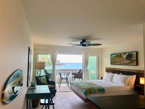 a bedroom with a bed and a view of the ocean at Kona Tiki Hotel in Kailua-Kona
