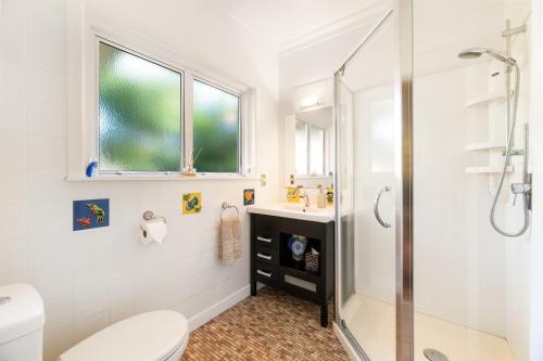a bathroom with a shower and a toilet and a sink at Grange Harbour View B&B in Tauranga