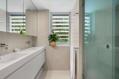 a white bathroom with a sink and a shower at Little Cove Court - Apt 8 in Noosa Heads