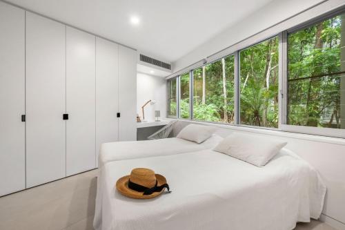a bedroom with two beds and a hat on a bed at Little Cove Court - Apt 8 in Noosa Heads