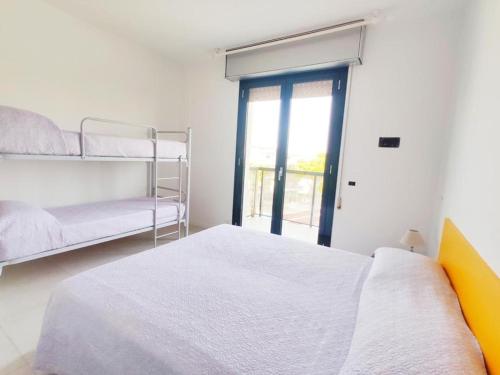een slaapkamer met 2 stapelbedden en een raam bij QUITO - Appena Ristrutturato - Dietro Piazza Mazzini - Immbil Relax in Lido di Jesolo