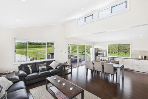 a living room with a couch and a table at Romantic lakehouse set in a private vineyard in the Hunter Valley in Lovedale