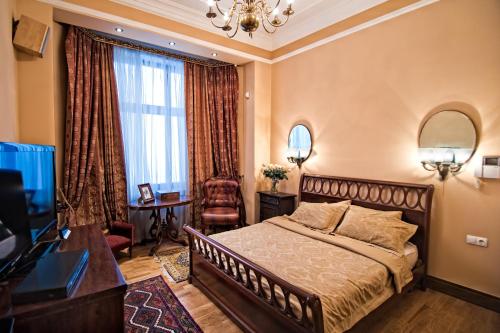 a hotel room with a bed and a television at British Club Lviv in Lviv
