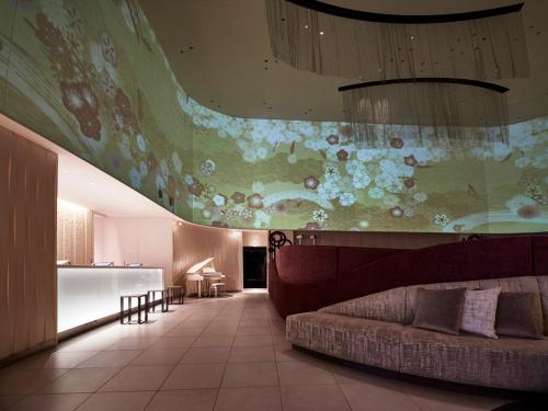 a living room with a couch and a painting on the wall at Hotel Metropolitan Saitama-Shintoshin in Saitama