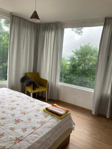 ein Schlafzimmer mit einem Bett und einem großen Fenster in der Unterkunft Kokhta guest house On the mountain in Jvari