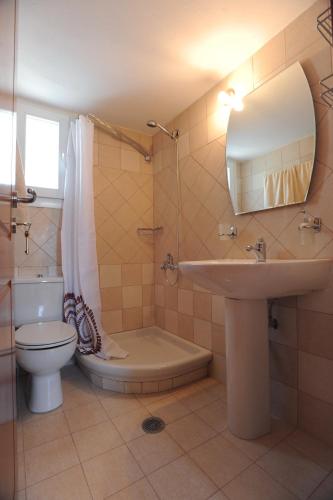a bathroom with a sink and a toilet and a mirror at Veranta Me Thea in Agios Ioannis