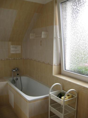 uma banheira na casa de banho com uma janela em Pension Kristýna em Kašperské Hory
