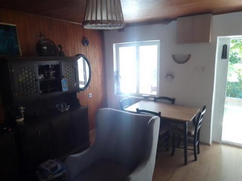 uma cozinha com mesa e cadeiras e uma janela em Manjina kuća em Fužine