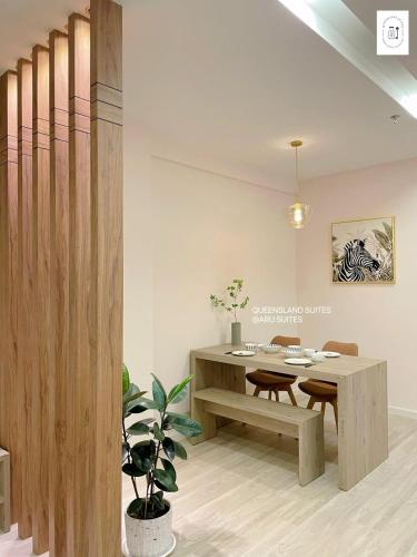 a dining room with a wooden table and a wooden fence at QUEENSLAND SUITES at Aru Suites, Kota Kinabalu in Kota Kinabalu