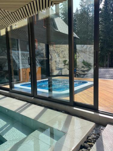a swimming pool seen through the windows of a house at Rtanj Kopaonik Eco Resort & Spa in Kopaonik