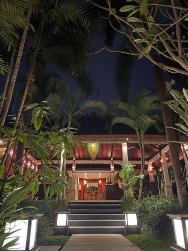 a resort with stairs and palm trees at night at Villa Sabandari in Ubud