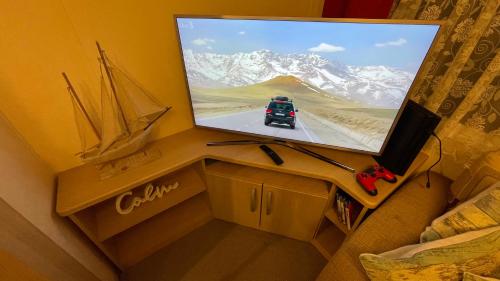 a tv sitting on top of a table with a tv on it at Cozy Private Static Caravan at Llyons Robin Hood - Silver Birch Way 11 in Rhyl