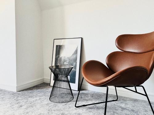 a chair and a vase next to a picture at Pension MONO - Adults Only in Český Krumlov