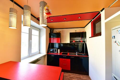 a kitchen with red cabinets and a red counter top at Travel Apartment in Ventspils