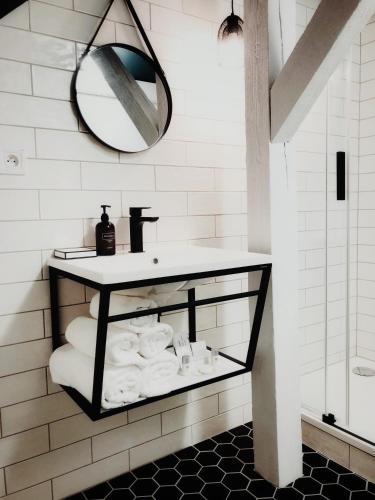 a bathroom with a sink and a mirror and towels at Pension MONO - Adults Only in Český Krumlov