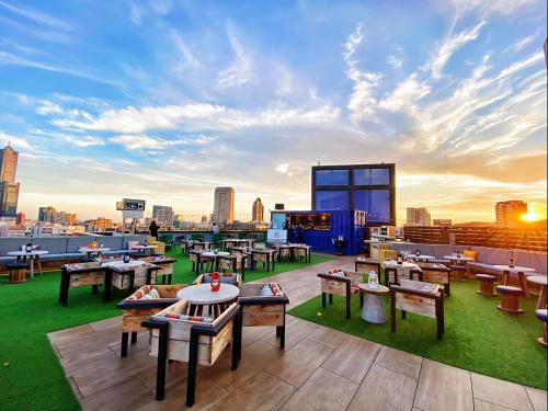 a rooftop patio with tables and chairs on top of a building at Hotel Indigo Kaohsiung Central Park, an IHG Hotel in Kaohsiung