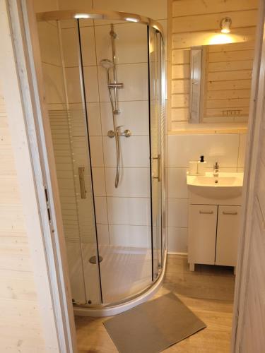 a bathroom with a shower and a sink at Domki Weekend in Rusinowo
