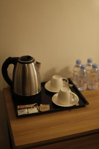 a tray with a tea kettle and cups on a table at El Sancho Hotel in Naga