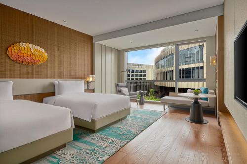 a hotel room with two beds and a large window at Artyzen Lingang Shanghai in Shanghai