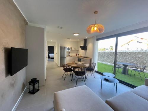 a living room with a couch and a table with chairs at Apartamentos Las Indianas in Nueva de Llanes