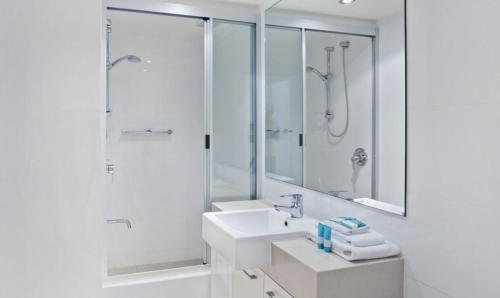 a white bathroom with a sink and a shower at Little Cove Court - Apt 10 in Noosa Heads